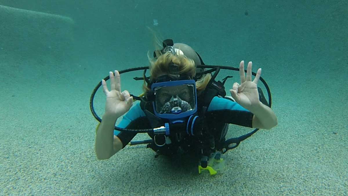 Photo of woman giving OK sign underwater with Ennis Cuba Diving in Ennis Texas